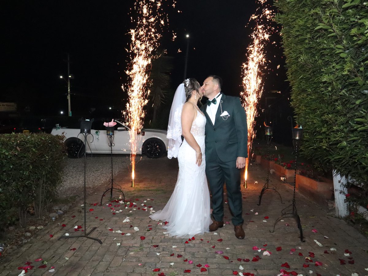 Beso de los novios entre chispas frías a la entrada