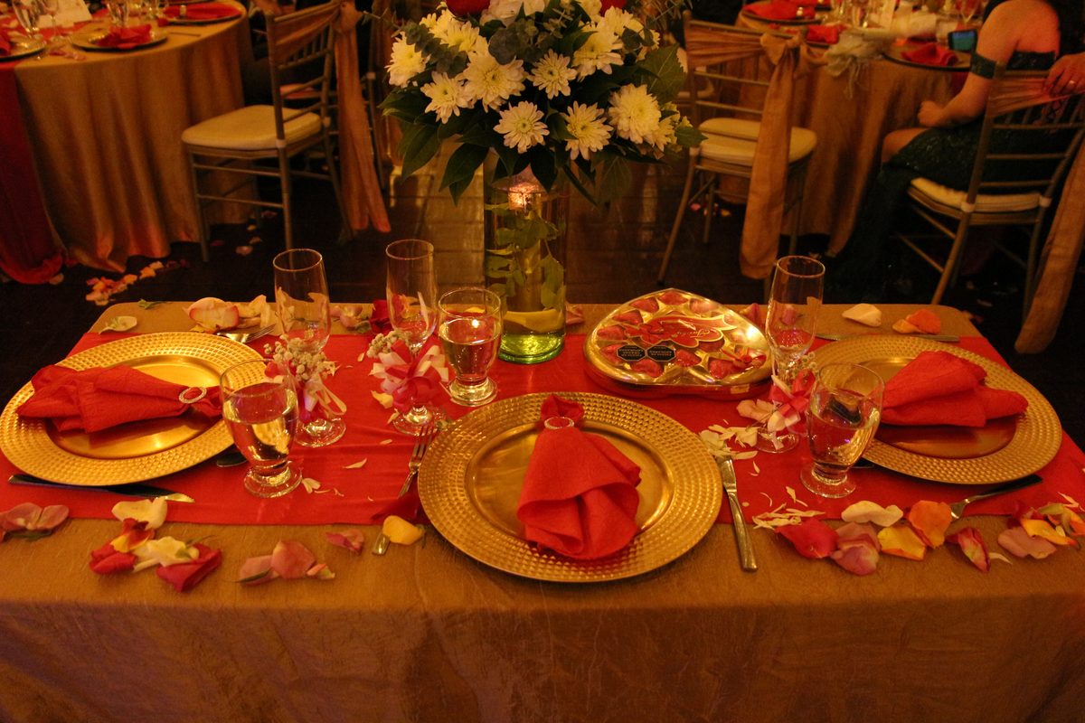 Mesa de boda montada en rojo y dorado