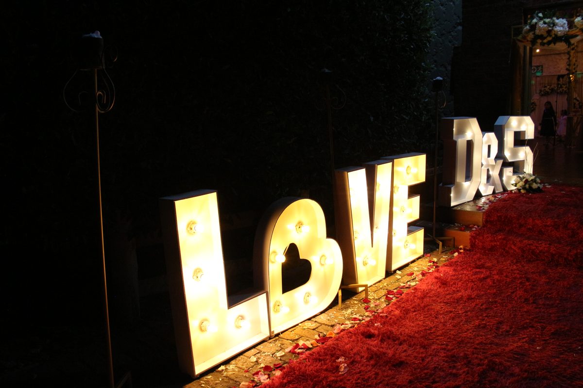 Letras LOVE iluminadas con alfombra roja de noche
