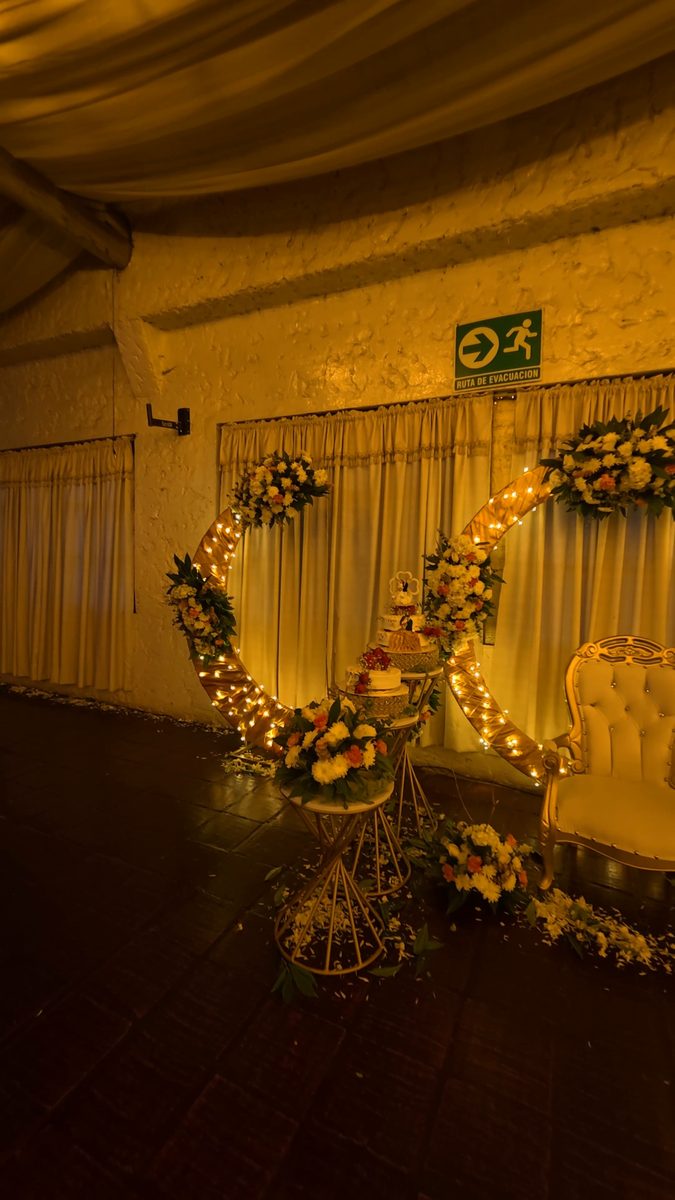 Aro floral iluminado con la silla y la mesa de la torta