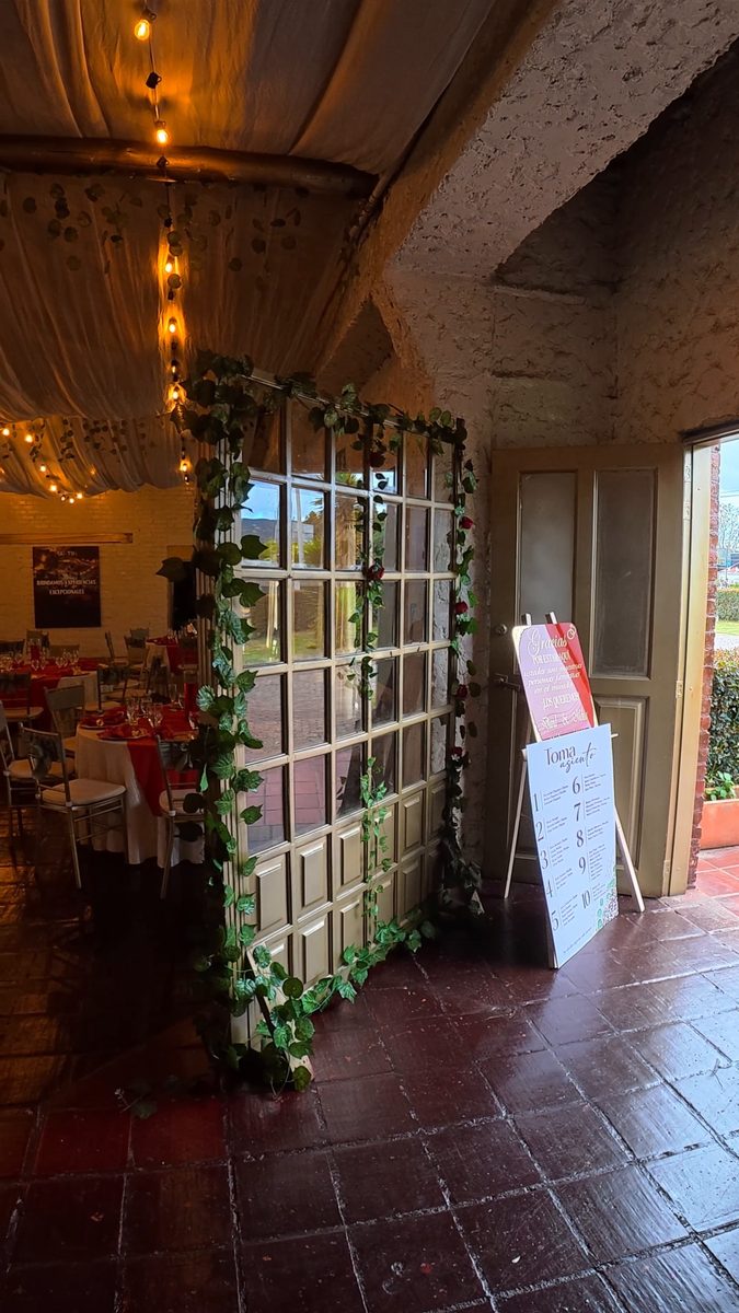 Puerta decorada con enredadera y el plano de mesas