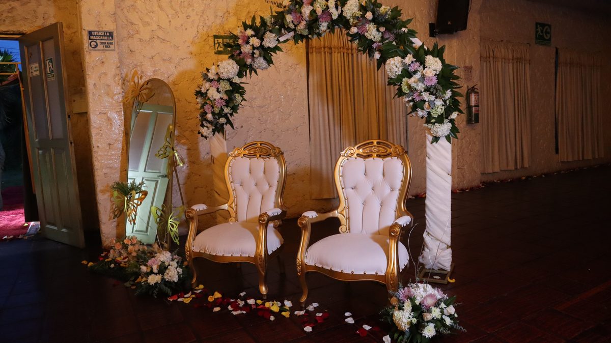 Arco floral con sillas doradas para la ceremonia