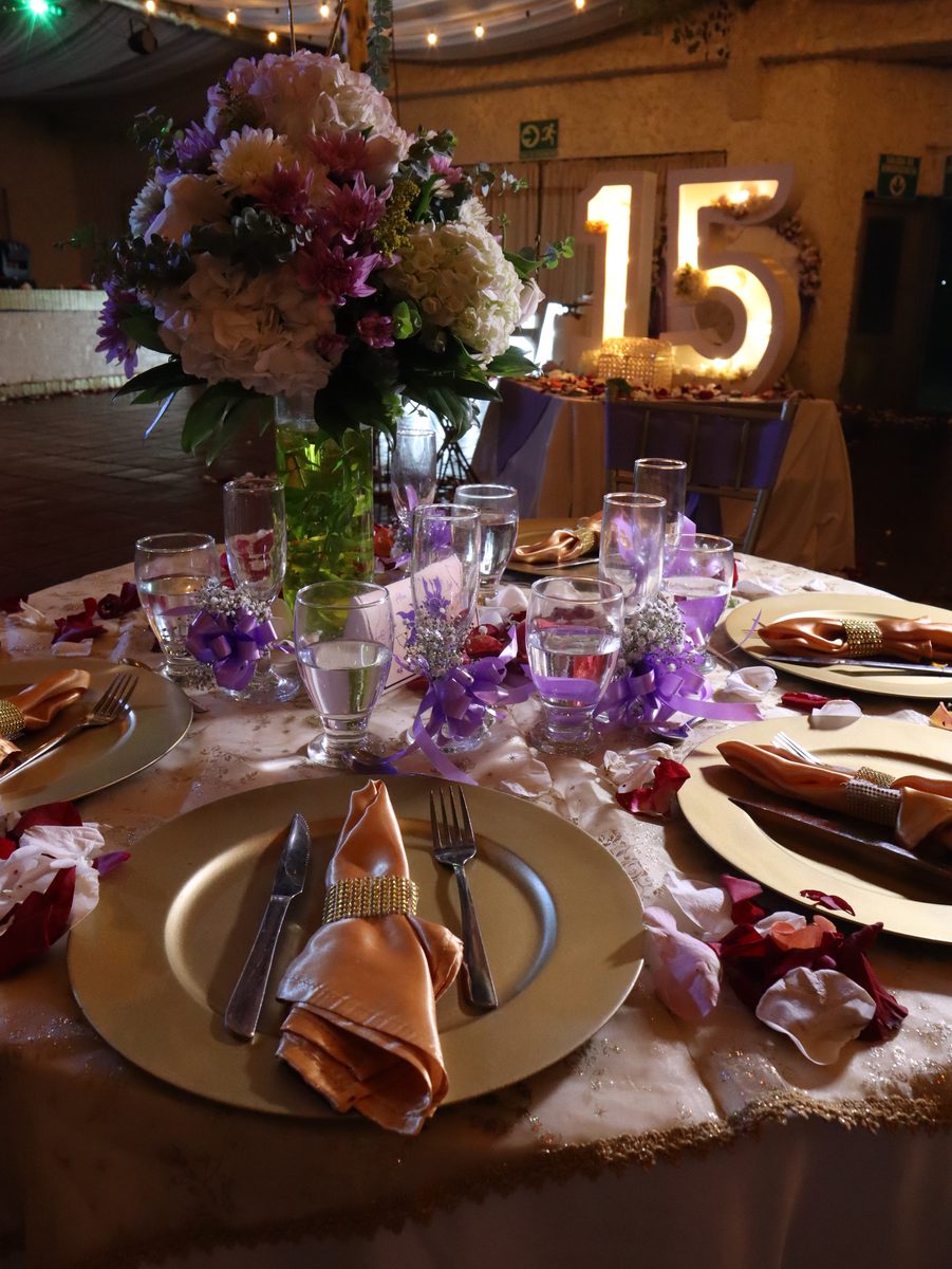 Puesto de mesa con centro floral alto en lila y dorado