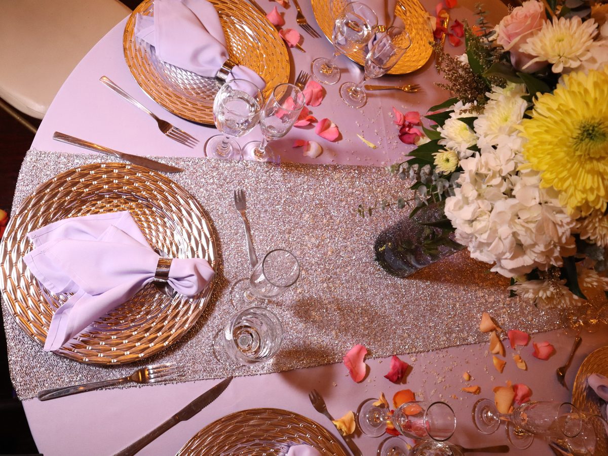 Puesto de mesa visto desde arriba con flores y pétalos