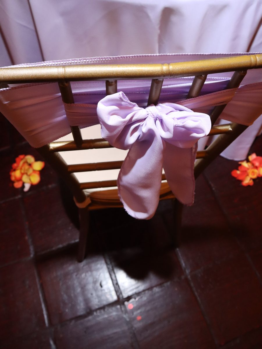 Silla dorada vestida con moño en lila