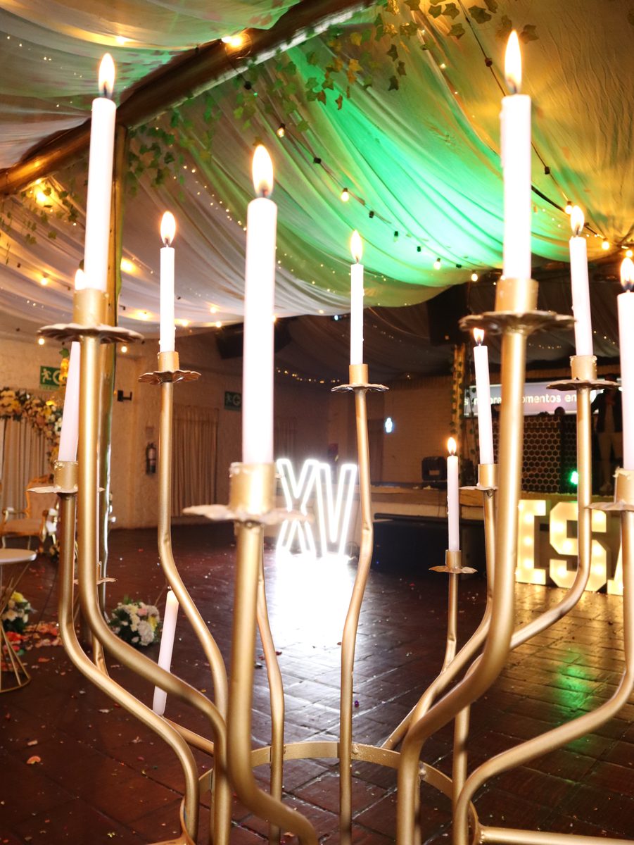 Candelabros dorados con velas encendidas en el salón