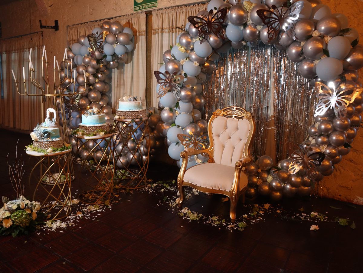 Arco de globos plateado con el trono y la mesa de la torta
