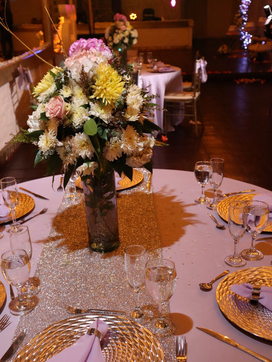 Centro floral alto sobre la mesa de invitados